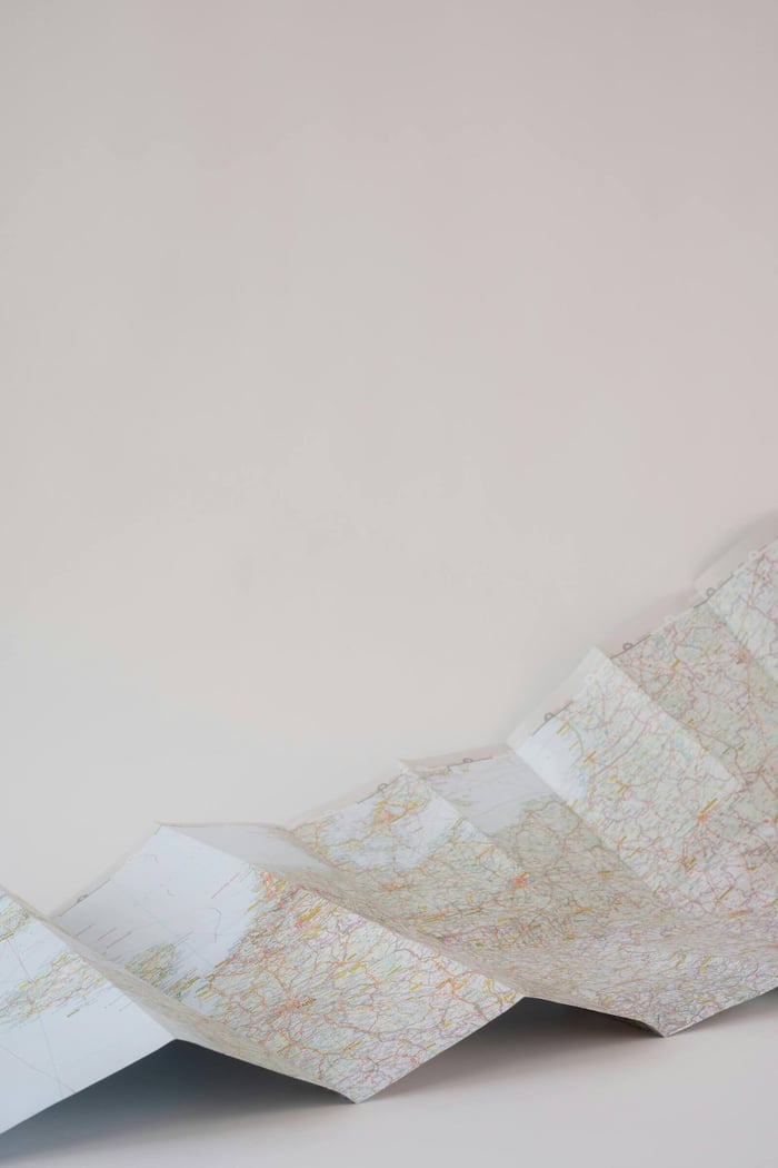 Folded paper map with intricate details on a plain white background.