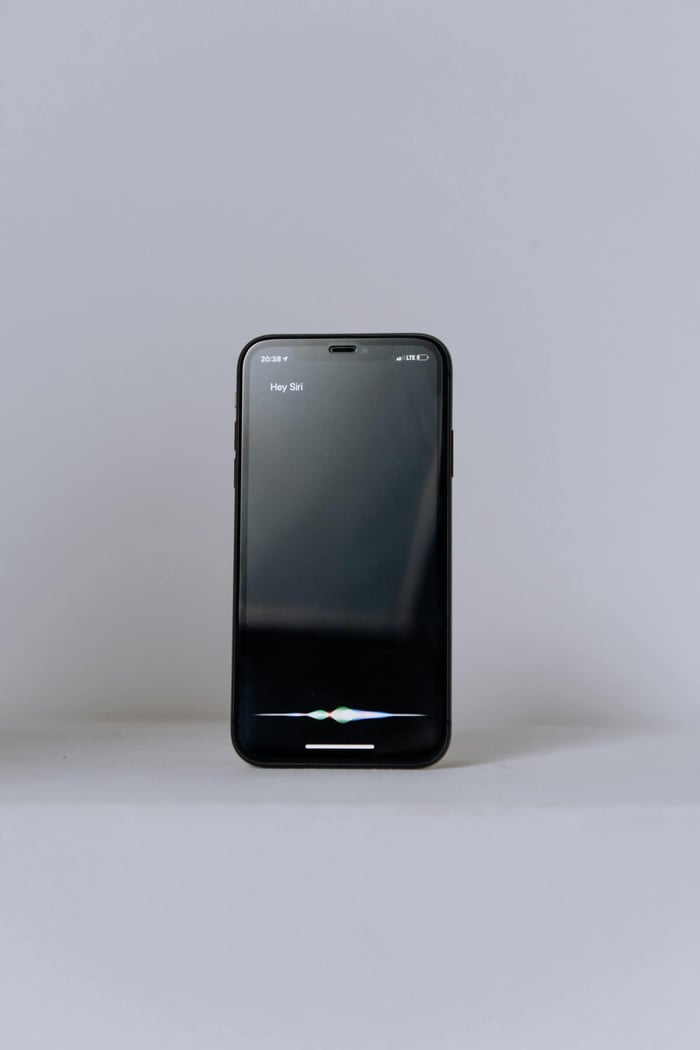 Minimalist photo of a smartphone displaying a virtual assistant on a neutral background.